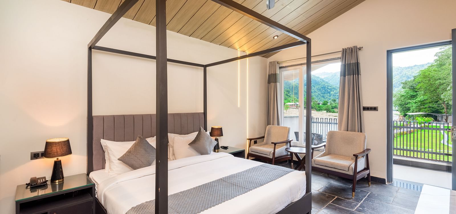 Luxury cottage at DLS Divine River Resort and Spa featuring a bed, chairs and a private balcony 